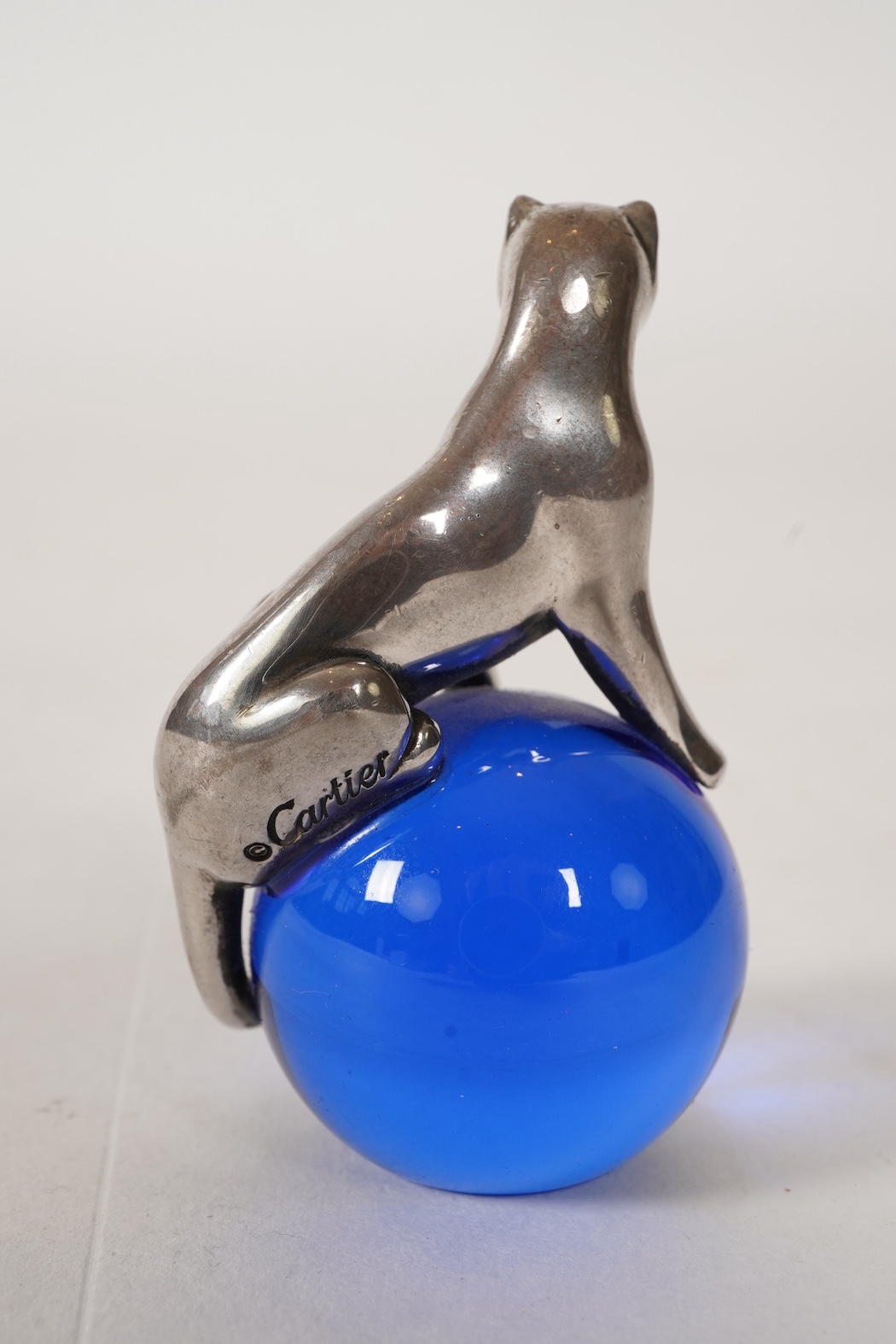 A recent Cartier paperweight, modelled as a panther upon a blue glass sphere